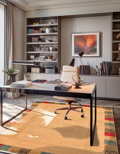 an office area with a desk, chair and bookshelf in front of a window