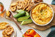 an assortment of food including crackers, vegetables and dip