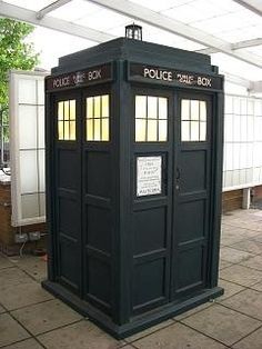 a black phone booth sitting inside of a building