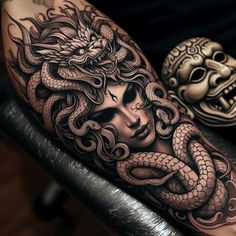 a woman with a dragon tattoo on her arm next to a mask and snake head