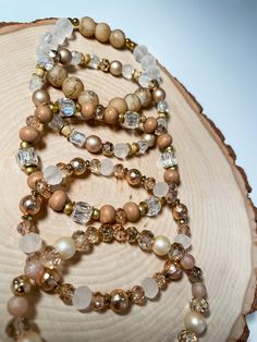 a necklace with many different beads on top of a piece of wood and another bead