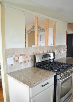 a stove top oven sitting inside of a kitchen next to a wall under construction beams