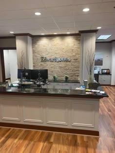 an office with wood flooring and stone wall behind the counter top is a computer desk