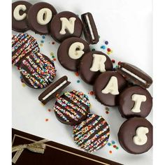 chocolate covered cookies are arranged in the shape of letters spelling out congrats and decorated with sprinkles