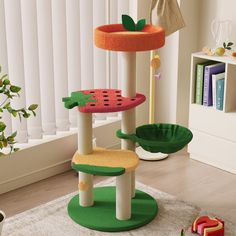 a cat tree in the middle of a living room with toys on the floor and bookshelf behind it