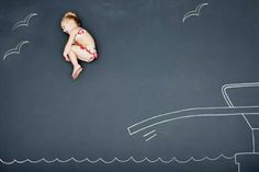 a baby in a red and white diaper sitting on the ground