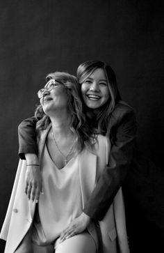 black and white photograph of two women sitting next to each other with their arms around one another