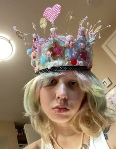 a woman with blonde hair wearing a pink and blue crown on top of her head