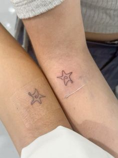 two people with matching tattoos on their arms