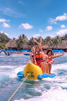 four people on a banana boat in the ocean