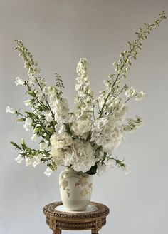 a vase with white flowers sitting on a table