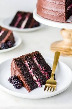 a slice of chocolate cake with raspberries on a plate next to a fork