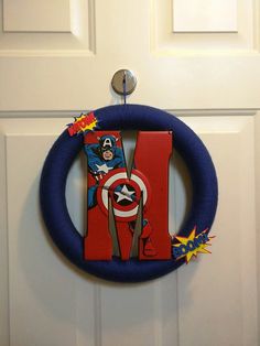 a door hanger decorated with the letter i and superheros on it's side