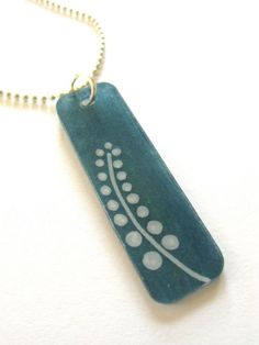 a blue necklace with white dots on it