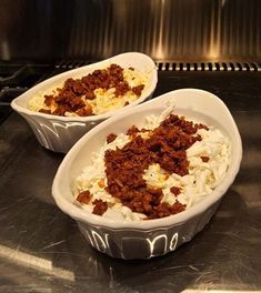 two bowls filled with food sitting on top of a stove