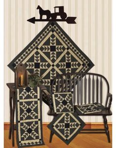 a black and white quilt sitting on top of a chair next to a wooden table