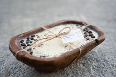 a small wooden bowl filled with coffee beans and vanilla ice cream, tied with twine