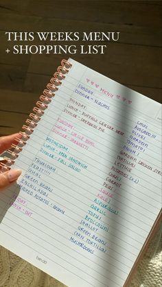 a person holding a notebook with the words this week's menu and shopping list