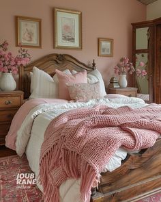 a bed with pink and white comforter in a bedroom next to two pictures on the wall