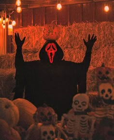 a person in a dark room with skulls and pumpkins