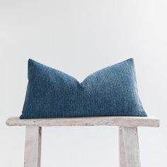 a blue pillow sitting on top of a wooden stool