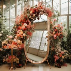 a large mirror sitting on top of a table next to two small tables with flowers