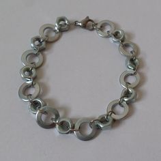 An extraordinary Bracelet with hexnuts and washers. Colour: silver  Size:  circumference: selectable (circumference of the bracelet in the picture: ca 18cm) The circumference of the bracelet can vary about a few millimetres Hexnut: ca 8mm Washers: ca 12mm Material: Hexnut & Washers : galvanized steel Spacer & Fastener : Stainless Steel In additional offers in my shop you can also buy the appropriate Necklace (shown in the last picture), Earrings, Earstuds and a Choker. Warning: Not suitable for Picture Earrings, Galvanized Steel, Steel Chain, Chain Link Bracelet, Link Bracelets, Arm Band, Industrial Style, Chain Link, Jewelry Bracelets