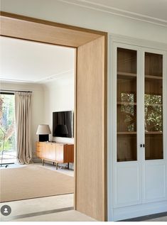 a living room filled with furniture and a flat screen tv on top of a wooden cabinet