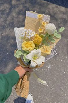 someone is holding a bouquet of flowers on the street