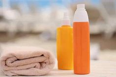 two bottles and a towel are sitting on the floor next to each other, one is orange