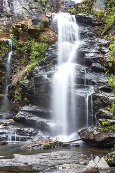 a large waterfall in the middle of a forest