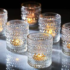 several clear glass candles are lined up on a table