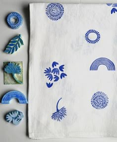 blue and white handmade napkins with designs on them next to other items that include buttons