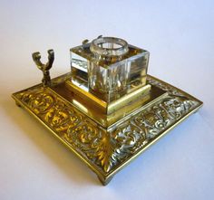 an ornate silver and gold plate with a candle holder in the shape of a square