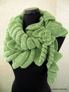 a green knitted scarf on top of a mannequin