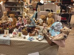 many stuffed animals are sitting on a table in a room filled with other stuff items