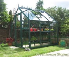 a small green house sitting in the middle of a yard