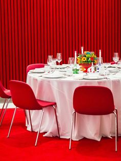 a round table with red chairs is set up for a formal dinner or banquet event