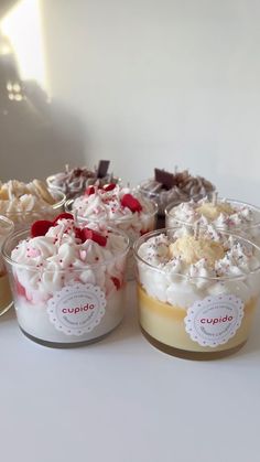 several desserts in small glass dishes on a white counter top with labels that say cupcake