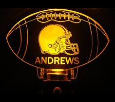 an illuminated football with the name and helmet on it is lit up in yellow light