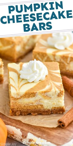 pumpkin cheesecake bars with whipped cream on top and cinnamon sticks in the foreground