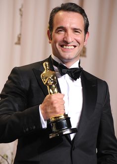 a man in a tuxedo holding an award