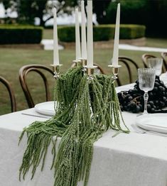 the table is set with candles and grapes