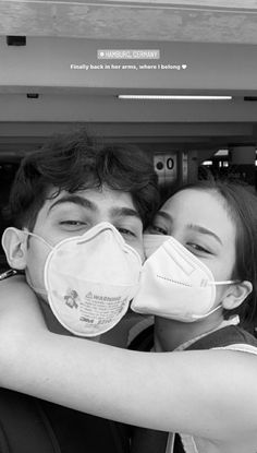 two people wearing masks hugging each other