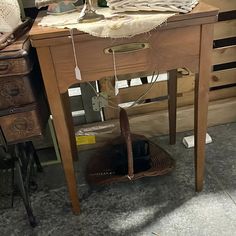 an old sewing machine sitting on top of a wooden table next to a basket filled with fabric