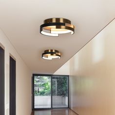 two circular lights are hanging from the ceiling in an empty room with wood flooring