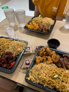 two trays filled with food sitting on top of a table