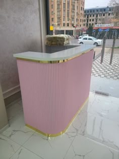 a pink and gold counter in front of a window