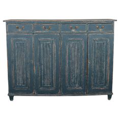 an old blue cabinet with three doors and two drawers