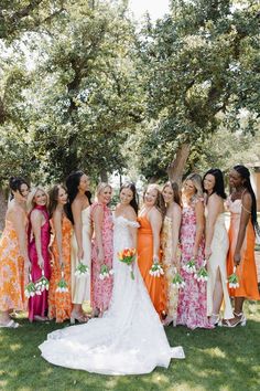 a group of women standing next to each other on top of a lush green field